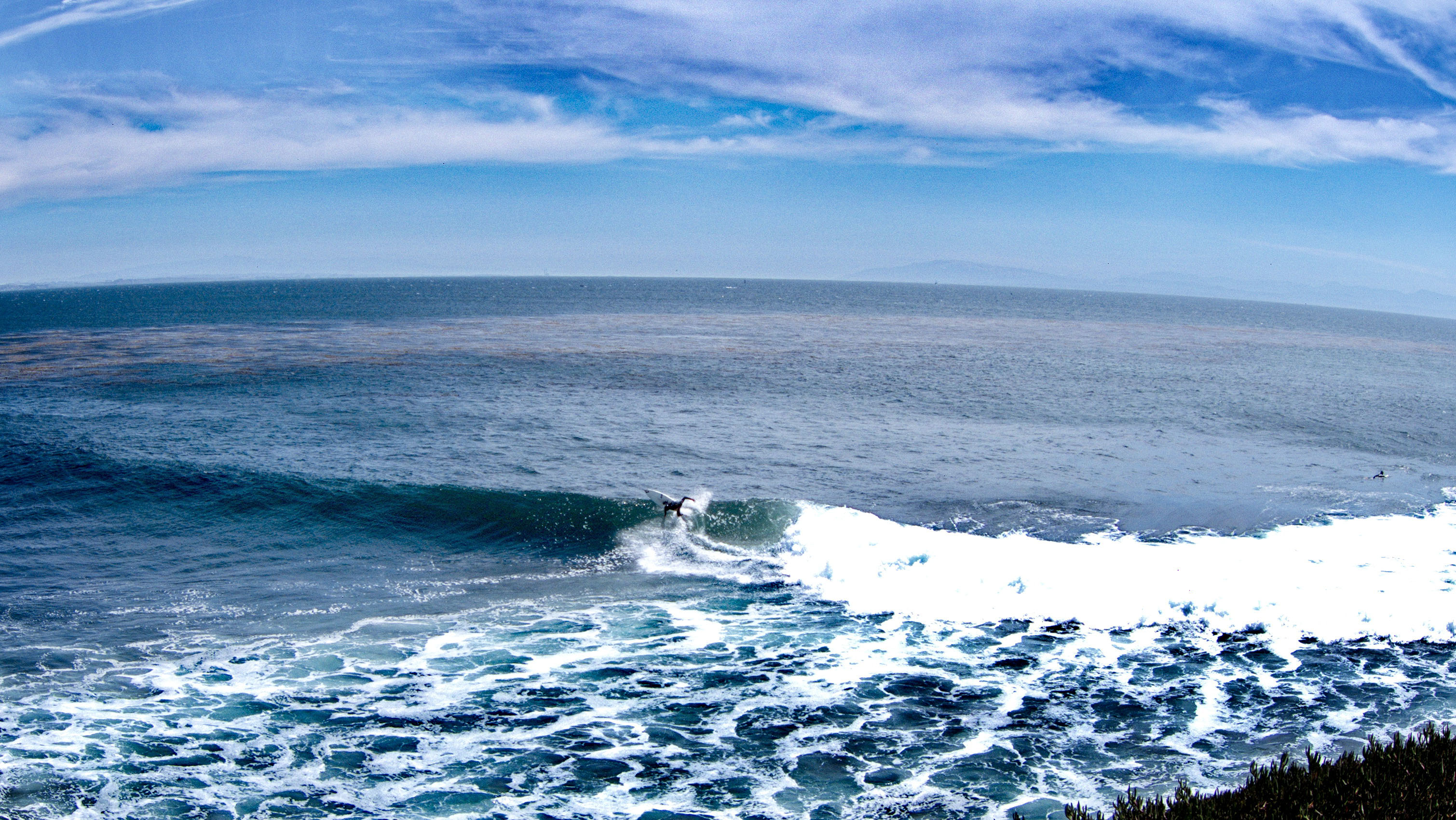 Surfer riding a wave at Steamer Lane along the Santa Cruz coastline